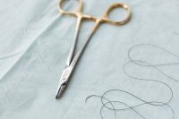 Kaboompics - Gold-Handled Dental Needle Holder on Surgical Drape
