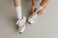 Kaboompics - Overhead View of White Sneakers and Ribbed Socks with Hands Tying Shoelaces