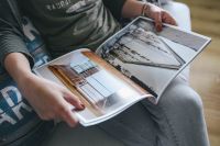 Kaboompics - Woman reading a designer magazine on a couch
