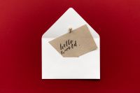 Kaboompics - White Envelope with Hello World Kraft Card on Red Background