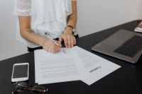 Kaboompics - Female Entrepreneur Completing Contract Paperwork at Desk