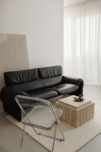 Kaboompics - Black Sofa, Chrome Chair and Travertine Coffee Table