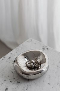 Kaboompics - Chrome Bowl with Metallic Jewelry on Marble Table