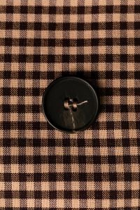 Kaboompics - Black Button on Gingham Fabric – Tailoring Detail Close-Up