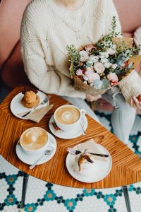 Kaboompics - Woman Holding a Pastel Bouquet above Cafe Coffee and Meringue Desserts