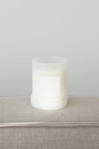 Kaboompics - White Candle Glass Resting on Its Lid on Neutral Fabric