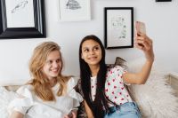 Kaboompics - Teen Friends Taking a Selfie on a White Sofa for Social Media and Friendship Campaigns