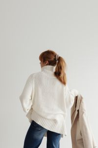 Kaboompics - Faceless Woman in White Sweater Holding Beige Coat from Behind