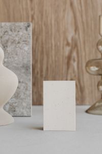 Kaboompics - Close-Up of Blank Card, Marble Sample and Soft-Focus Ceramic Vase on Warm Wood
