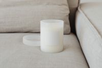 Kaboompics - White Glass Candle Mockup on Textured Beige Upholstery