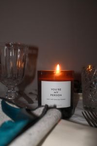 Kaboompics - Burning Amber Candle with Teal Ribbon Napkin
