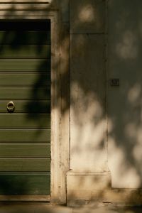Kaboompics - Green Door with Gold Knocker and Tree Shadows, Italian Street