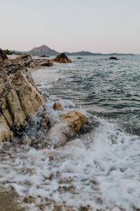 Kaboompics - White Surf Breaking at the Base of Coastal Rocks, Dynamic Summer Beach Background