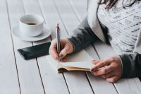 Kaboompics - Coffee on table with a woman writing