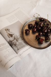 Kaboompics - Fresh Dark Cherries on a Wooden Plate Beside an Open Book