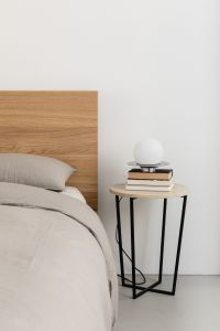 Kaboompics - Stacked Books and Round Lamp Beside a Bed