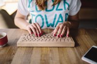 Kaboompics - Closeup of female hands typing text on a wireless wooden keyboard
