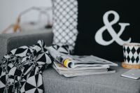 Kaboompics - Cozy Sofa Still Life with Magazines, Coffee Cup and Geometric Throw