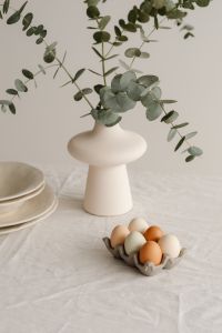 Kaboompics - White Ceramic Vase And Pastel Eggs On Linen Table