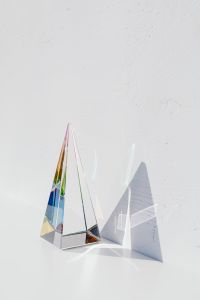 Kaboompics - Clear Triangular Prism Against Textured White with a Long Graphic Shadow