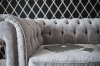 Kaboompics - Silver laptop and an iPhone on a grey sofa