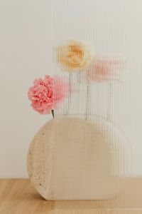 Kaboompics - Pink Carnation and Yellow Bloom Framed by Round Travertine and Ribbed Glass