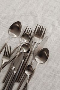 Kaboompics - Modern Stainless Steel Cutlery Arrangement on Textured White Fabric