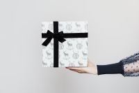 Kaboompics - Minimal White Christmas Gift Box with Black Ribbon Held in Hand, Clean Holiday Product Background