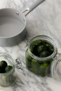 Kaboompics - Open Glass Jar Filled with Cucumbers beside a White Saucepan