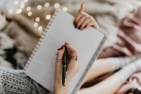 Kaboompics - Writing in a notebook lying in bed, with coffee, candles, and gingerbreads