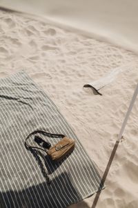 Kaboompics - Brown Leather Bag and Sunglasses on a Striped Beach Towel