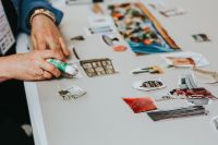 Kaboompics - Hand Arranging Cutout Images on Neutral Moodboard Background