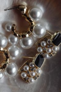 Kaboompics - Close-Up of Pearl and Black Stone Earrings with Gold Settings