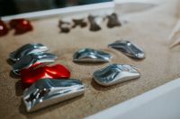 Kaboompics - Red and Chrome Abstract Metal Forms on a Sand-Colored Display