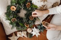 Kaboompics - Woman Making Holiday Wreath with Paper Decorations