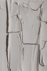 Kaboompics - Close-Up of Flaking White Paint and Shadowed Cracks