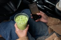 Kaboompics - Checking a Smartphone While Holding Iced Matcha in a Car