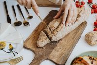 Kaboompics - Woman Cutting Bread on a Wooden Board