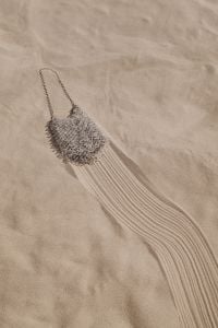 Kaboompics - Silver Beaded Mini Bag on the Sand with Long Strap