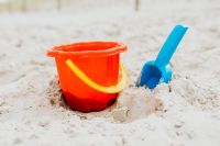 Kaboompics - Orange Sand Bucket and Blue Shovel on the Beach for Children's Play