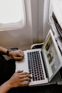 Kaboompics - Unrecognizable man with notebook sitting inside an airplane