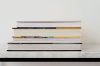 Kaboompics - Horizontal Stack of Books on White Marble Table, Neutral Background