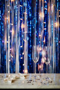 Kaboompics - Champagne Flutes on Blue Metallic Fringe with Clean Copy Space