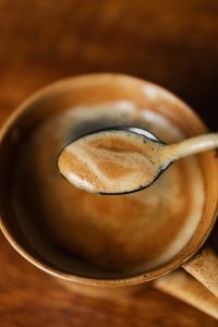 Kaboompics - Macro Coffee Foam and Ceramic Cup Rim Against a Warm Brown Background
