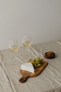 Kaboompics - Camembert, Grapes, and Wine on a Wooden Board