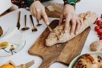 Kaboompics - Woman Slicing Bread in a Floral Apron