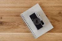 Kaboompics - Overhead Olympus Trip 35 on a Linen Notebook, Analog Photo Still Life