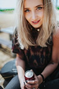 Kaboompics - Woman Taking a Beach Break on a Tree Stump with Cola Can