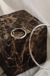Kaboompics - Silver Ring and Bangle on a Dark Marble Pedestal
