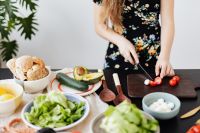Kaboompics - Slicing Cherry Tomatoes on a Dark Board beside Salad Bowl and Avocado
